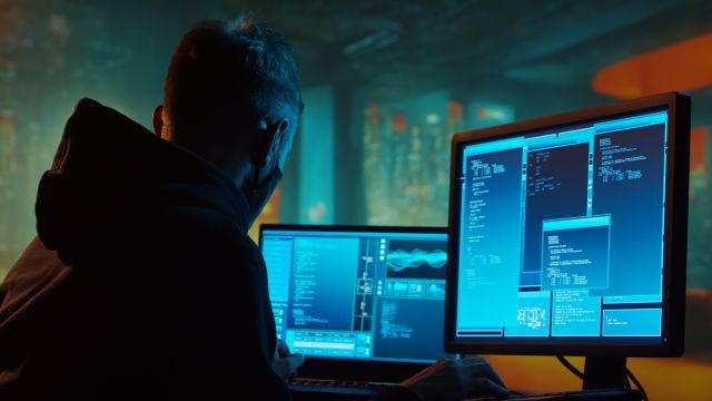Computer Hacker in Hoodie. Obscured Dark Face. Hacker Attack, Virus Infected Software, Dark Web and Cyber Security concept.